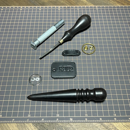 Component detail layout displaying 3D "MR" metal monogram stamp, edge slicker burnishing tool, solid brass Chicago screw, and leather keeper loop at Deco Leather Studio.